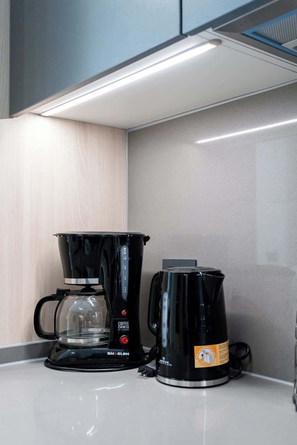 Modern kitchen equipped with a coffee maker and kettle, perfect for a cozy morning start!