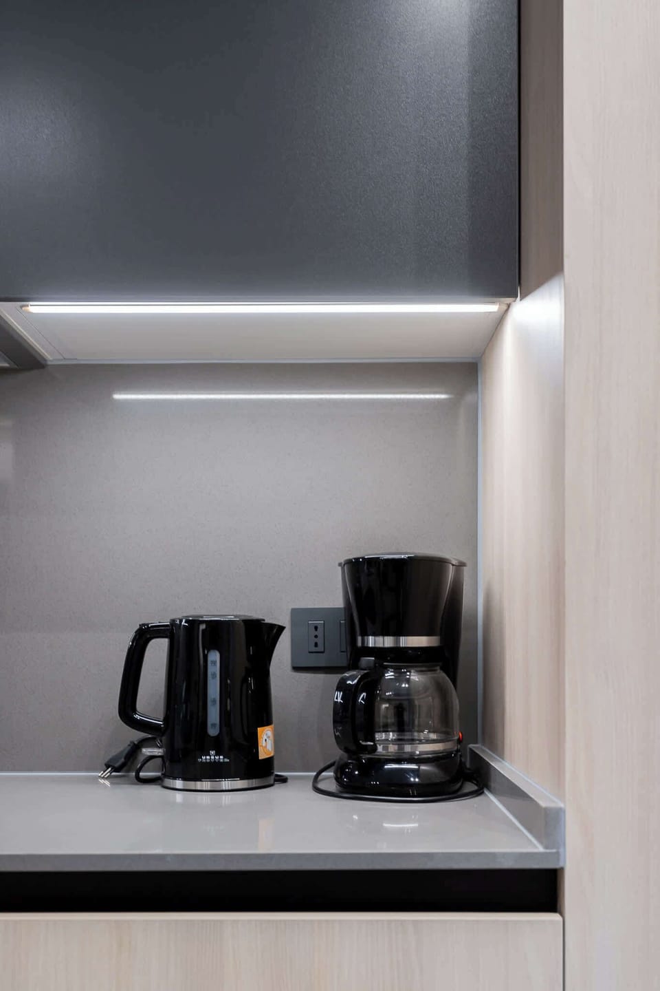 Sleek kitchen corner with modern appliances and ambient under-cabinet lighting for a stylish touch.