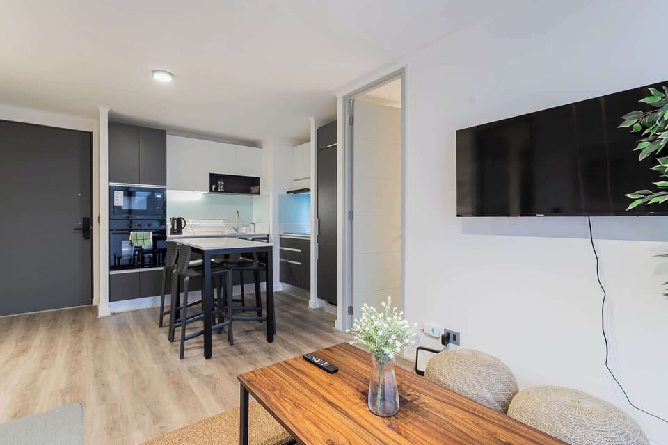 Cozy living space with modern amenities and a sleek kitchenette, perfect for a relaxing stay.