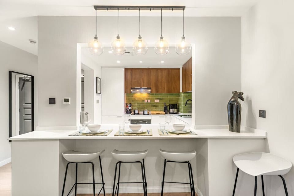 Modern Kitchen: Stylish open layout with chic bar seating and vibrant green backsplash!