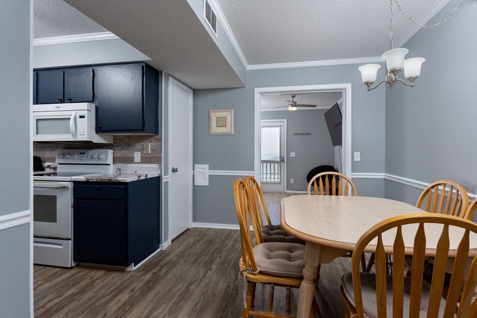 Gather around the dining table for meals in this open-concept space, where your kitchen flows seamlessly into the dining area—perfect for cooking and sharing stories together.