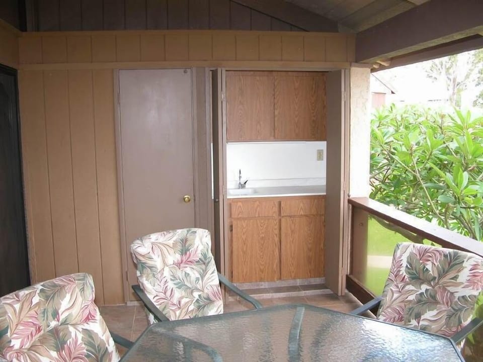 Covered lanai with built in wet bar and beautiful greenery, perfect for breezy outdoor meals.