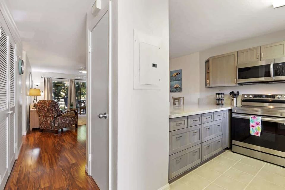 Entryway leads to a bright kitchen with stainless steel appliances and a glimpse into the inviting living area.