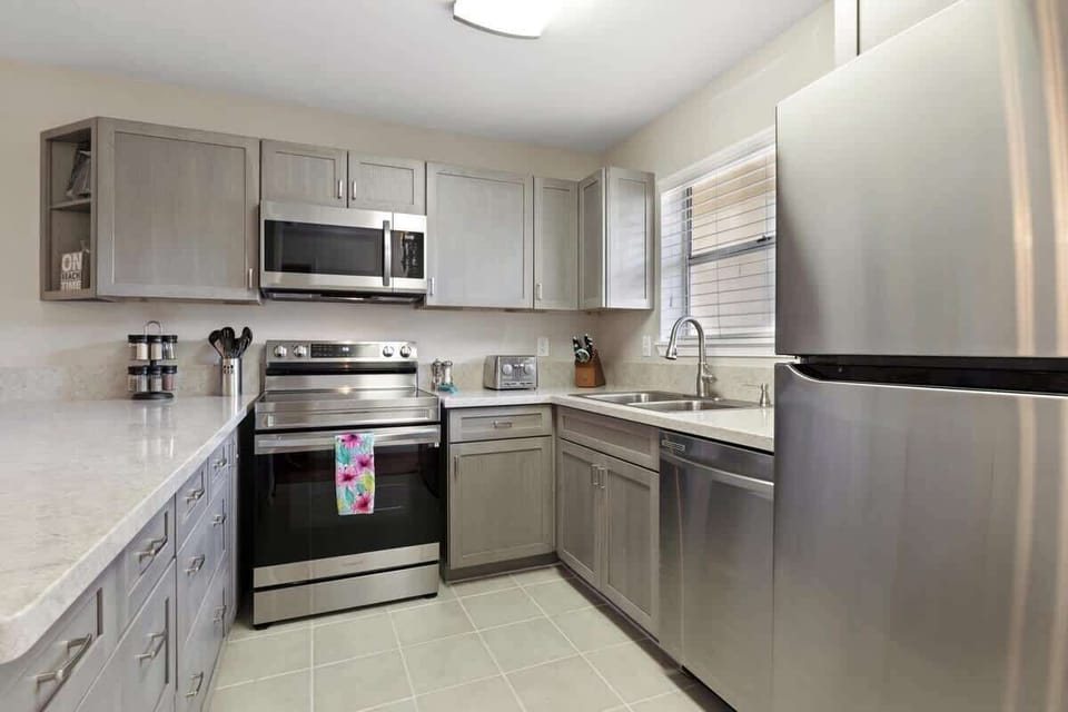 Cook with ease in this fully equipped kitchen featuring stainless steel appliances, stone counters, and sleek cabinetry.