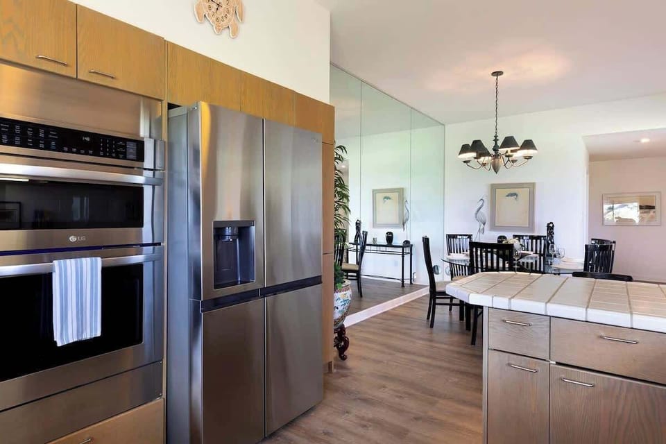 Enjoy an open layout with stainless appliances, wood cabinetry, and a mirrored wall for added charm.