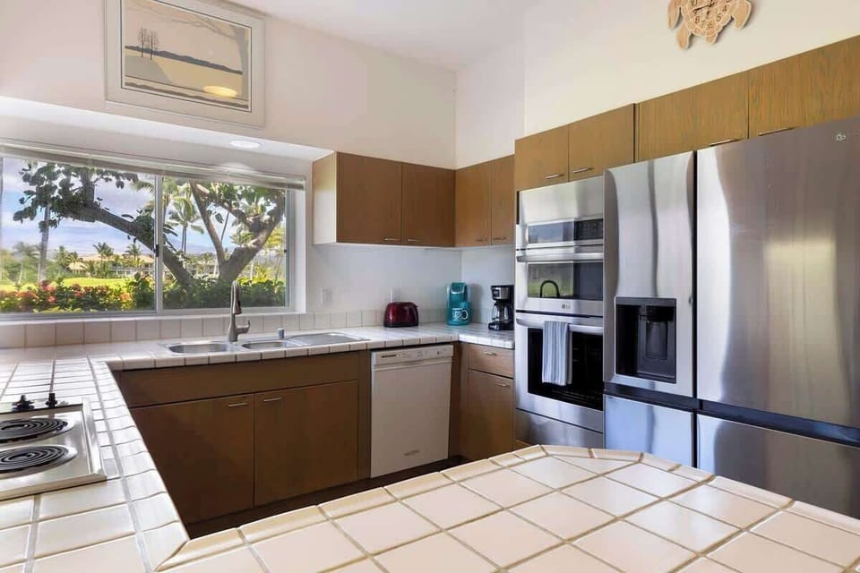 Start your mornings right with coffee in hand and serene greenery framed through the kitchen window.