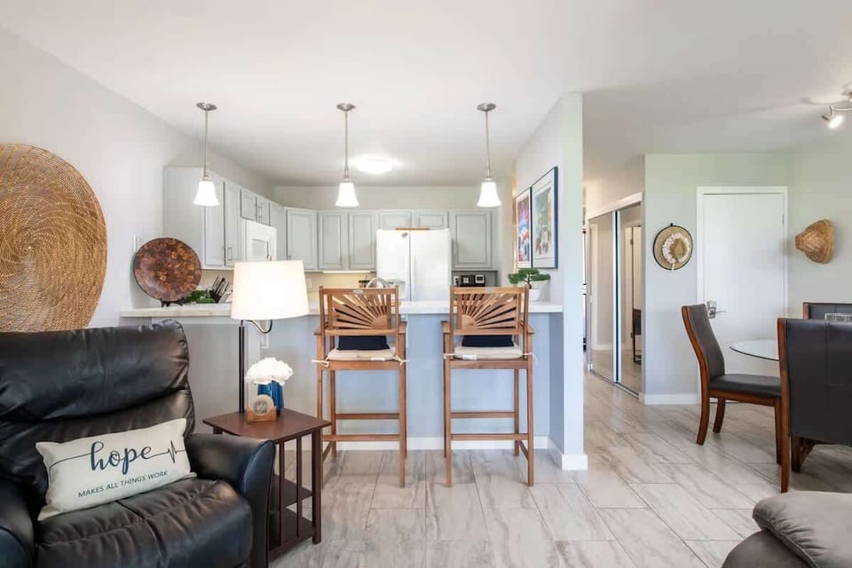 Open kitchen includes bar seating and pendant lights, perfect for quick meals or casual conversation.

