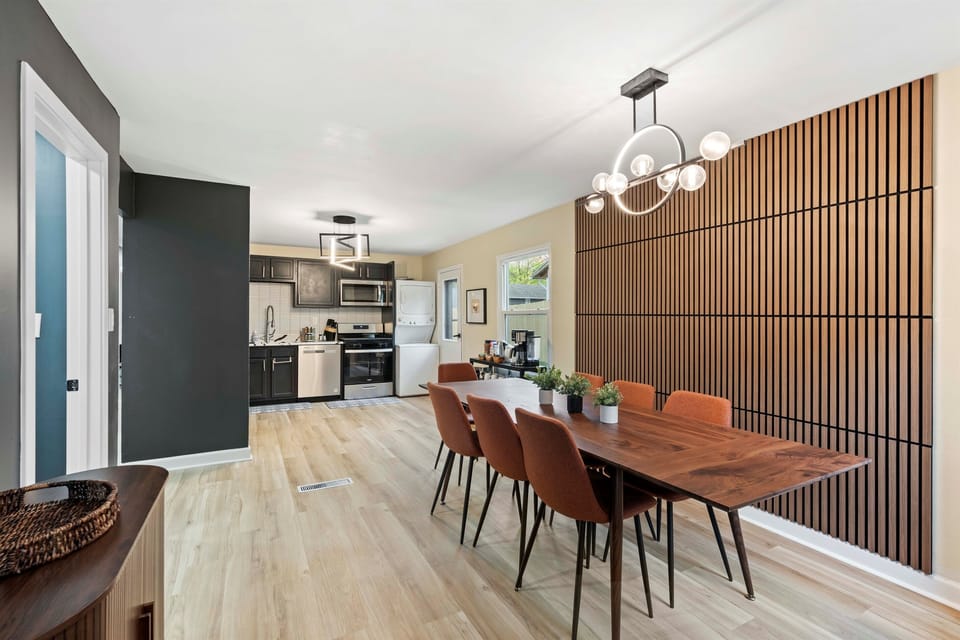 🍽️ Cook, Dine & Connect in Style Enjoy meals and memories in this sleek open-concept kitchen and dining area, featuring modern appliances, a bold accent wall, and seating for eight—perfect for family dinners or group getaways.