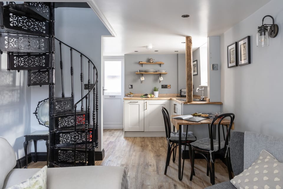 Open plan dining and kitchen area with stairs to upper floor - Apothecary Cottage