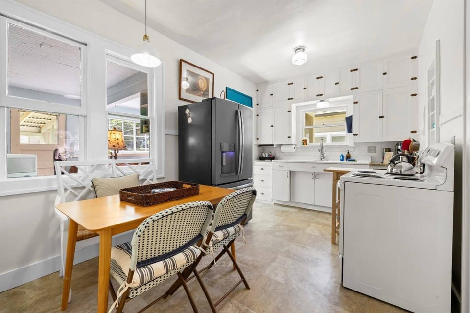 Eat-in kitchen with charming white cabinets, modern appliances, and a breakfast nook for coffee or casual meals