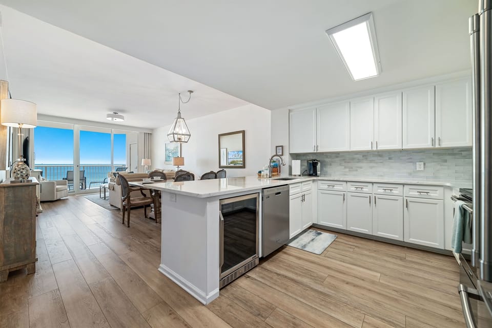 Gourmet kitchen with stainless steel appliances, granite countertops, and island seating. Open floor plan seamlessly connects to the living and dining areas.