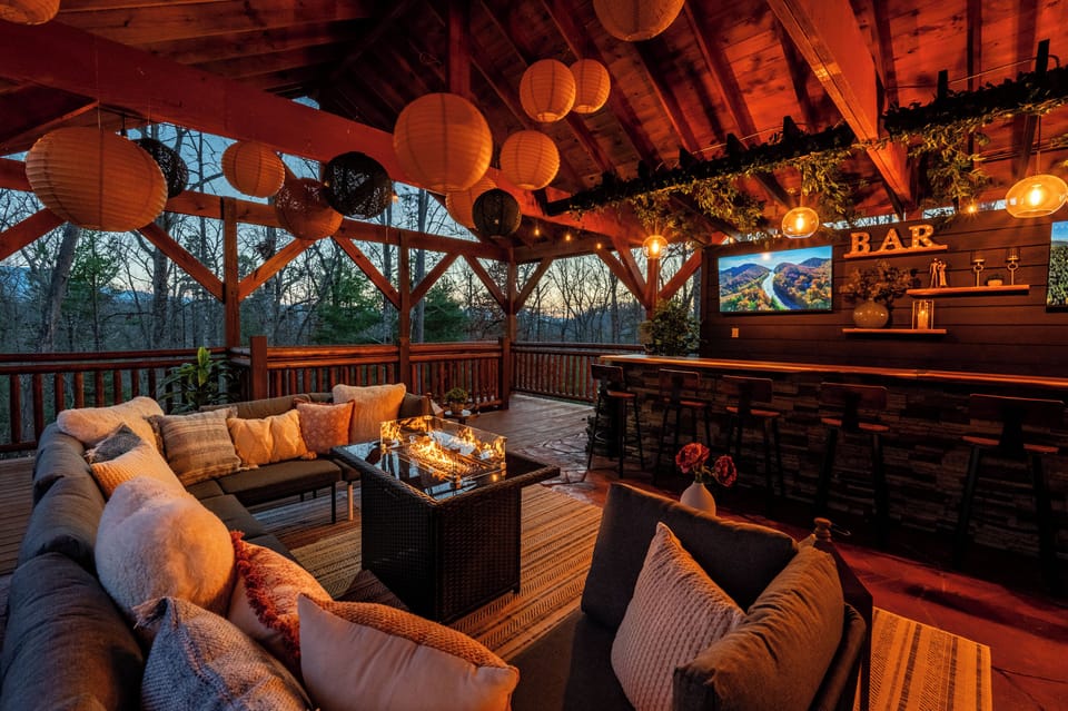 Custom outdoor bar with seating for 12, three wall mounted TV’s, and a cozy seating area with fire table.