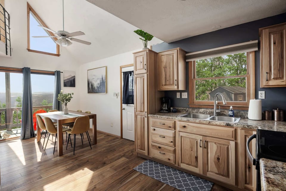 Natural light fills this rustic kitchen and dining area with views of the outdoors.