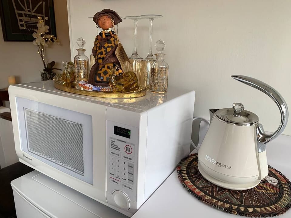 Kitchenette with crockery, cutlery, French Press, champagne and wine glasses