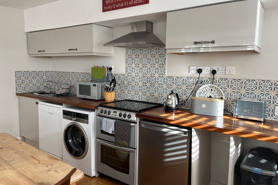 A fully equipped kitchen open-planned to the living room.