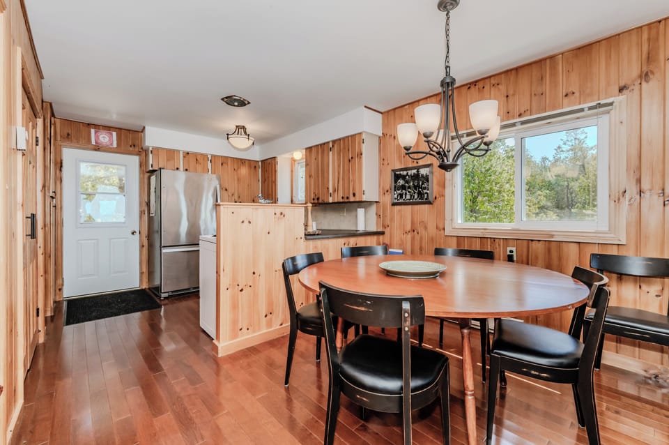 Spacious open-concept dining and kitchen area with rustic cottage vibes — your group’s perfect place to reconnect and enjoy vacation living.