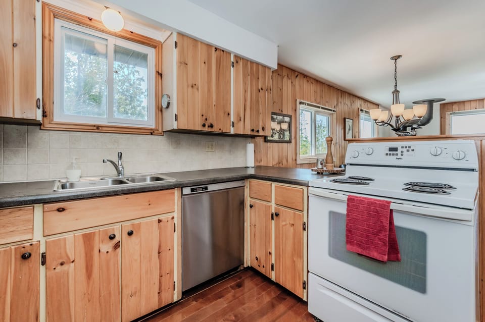 Charming rustic kitchen fully equipped for your lakeside stay, featuring natural wood cabinetry and all essentials for vacation cooking.