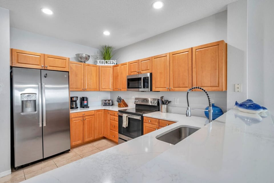 Fully equipped kitchen w/ stainless steel appliances, warm wood cabinets & ample counter space.