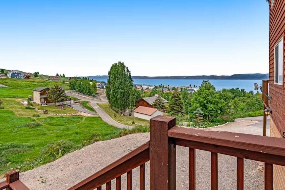 Gaze across the expansive property and lake from the upper deck, with rolling green lawns and pristine water views stretching before you.