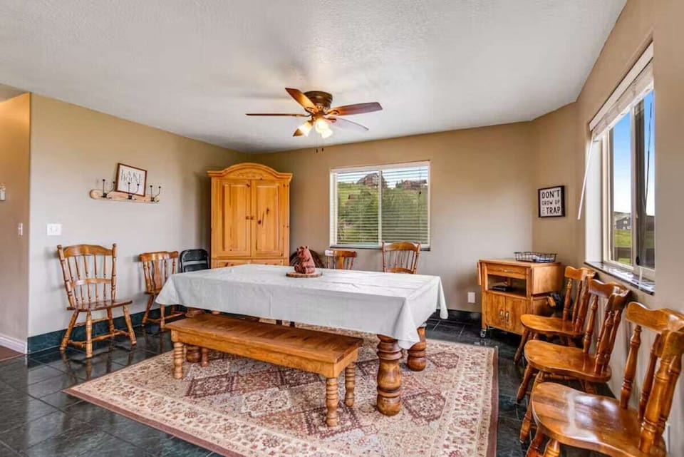 Share meals around this charming wooden dining table with comfortable seating and natural light from large windows.