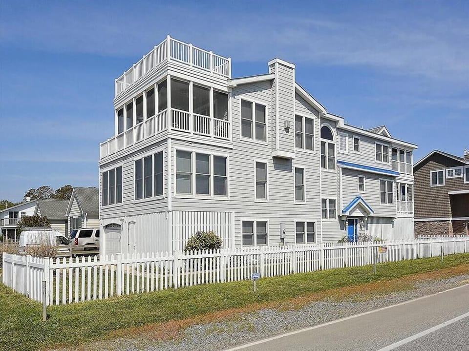 This stunning luxury beach home boasts breathtaking ocean views, multiple porches, and ample deck space that invites relaxation in the coastal breeze.