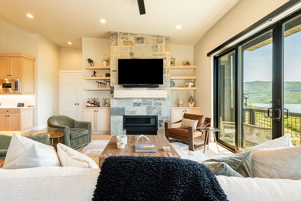 Main Living Room with TV, Balcony Access, Gas Fireplace, & remote blinds throughout