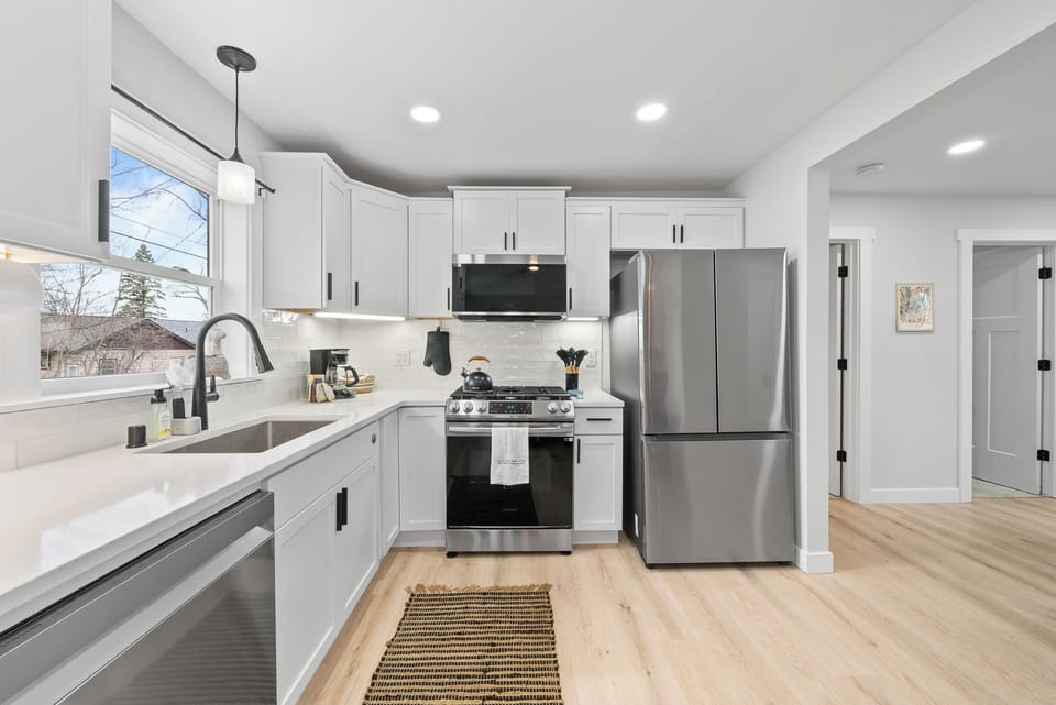 Fully equipped kitchen with dishwasher, refrigerator, gas stove/oven.