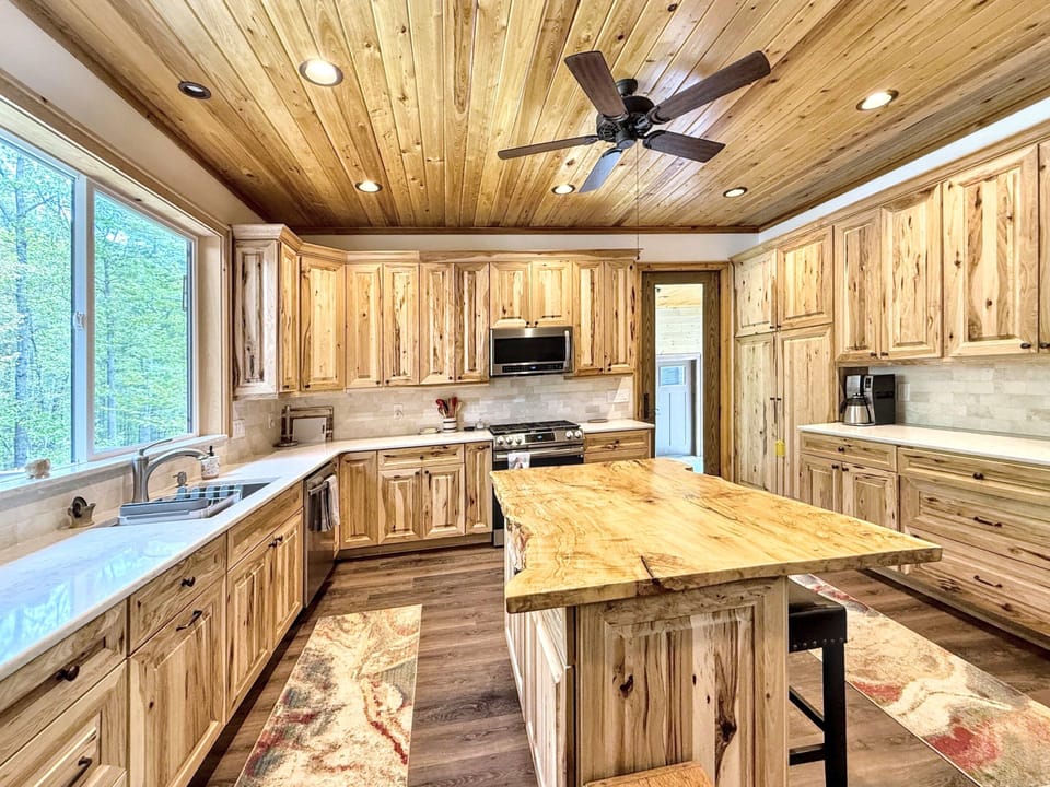 Expansive kitchen with stunning cabinetry, live edge island with stools