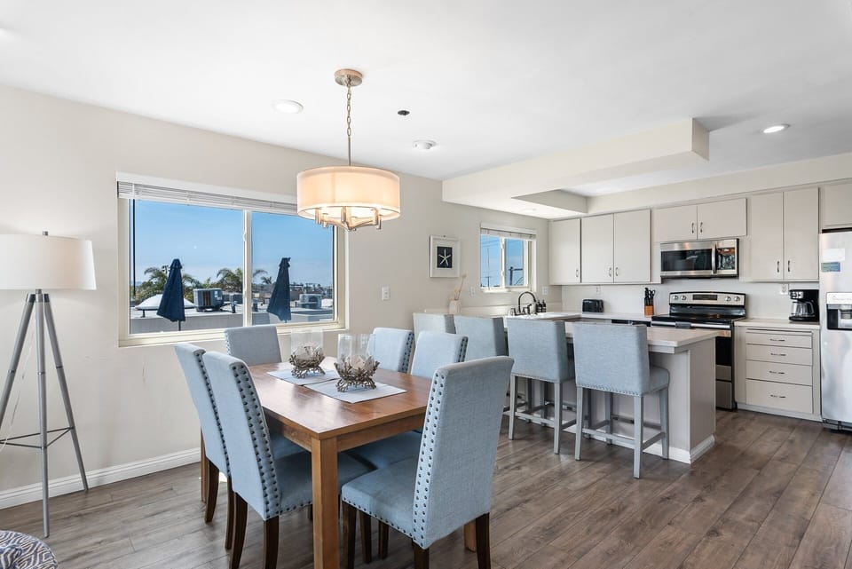 Open-concept kitchen and dining area designed for gathering and entertaining, featuring modern appliances, a spacious dining table, and plenty of natural light, perfect for cooking meals and enjoying time together.