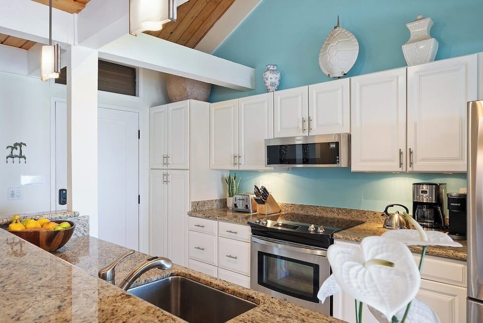 Fully equipped kitchen with  white cabinets and modern appliances