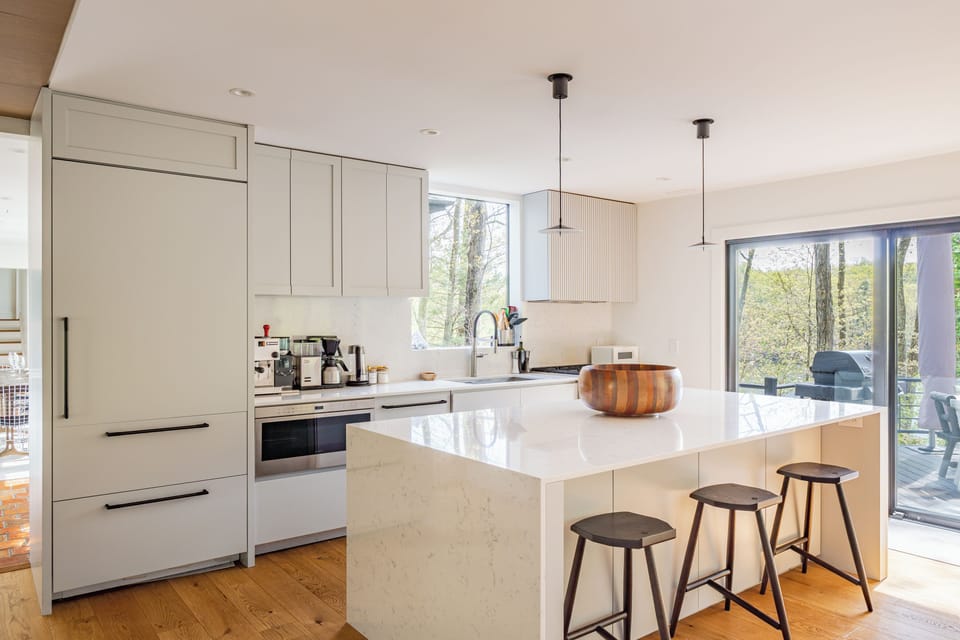 This spacious kitchen features an expansive island and sliding doors leading to the grill and outdoor dining area.