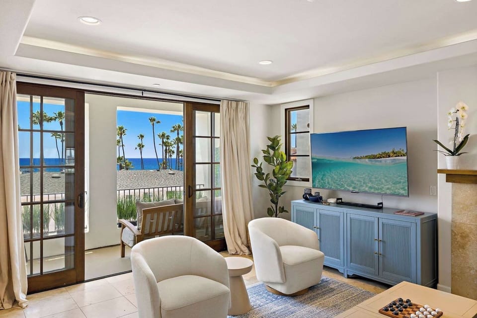 The living room has lots of comfortable seating, views and natural light pouring in from the balcony.