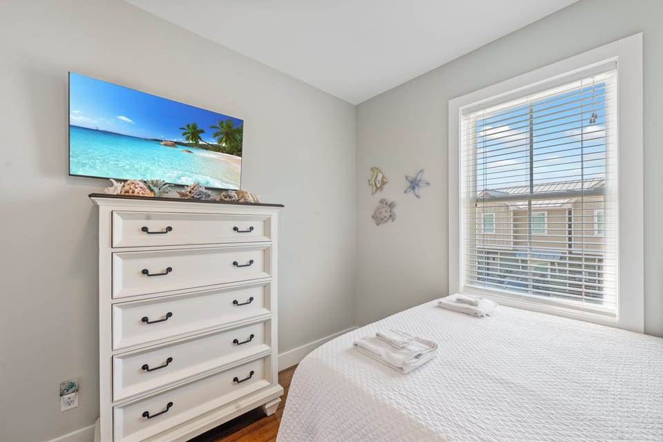 Wake up in your peaceful bedroom with coastal charm and tropical artwork creating the perfect seaside escape vibe.