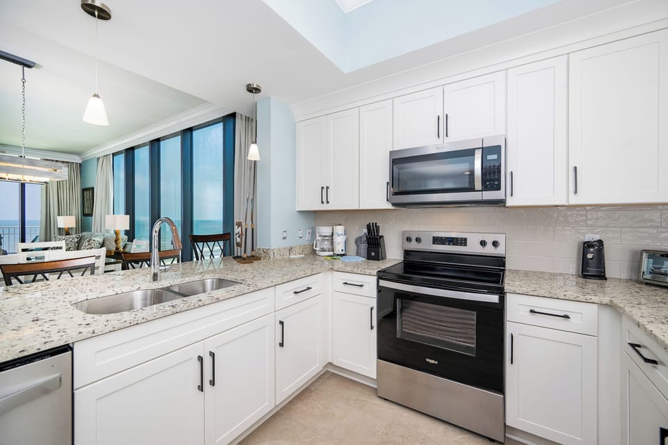 Prepare meals in the stylish kitchen with granite countertops, stainless appliances, and stunning beach view