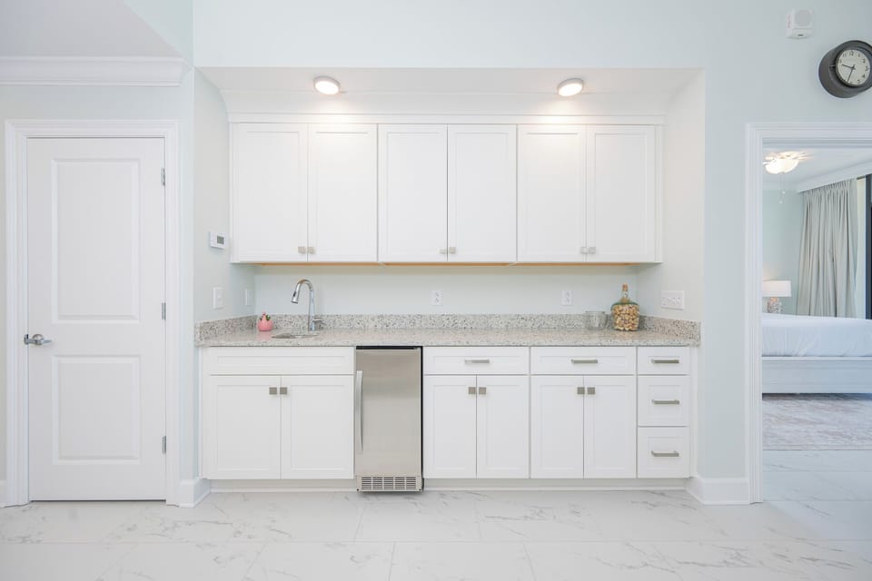 Enjoy preparing drinks in the sleek wet bar with granite countertops and modern cabinetry