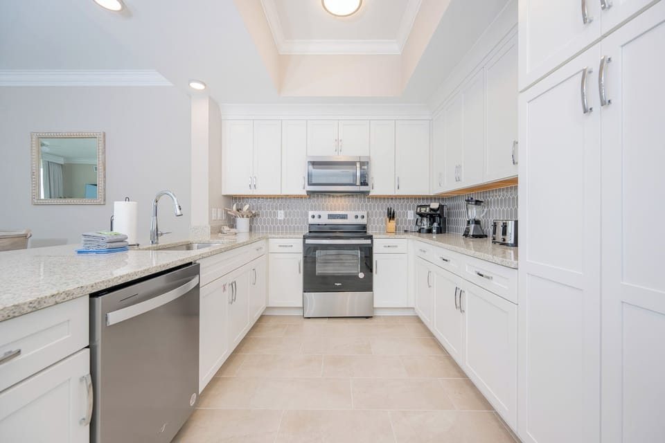 Prepare meals in this elegant kitchen with sleek countertops, stainless appliances, and stylish cabinetry