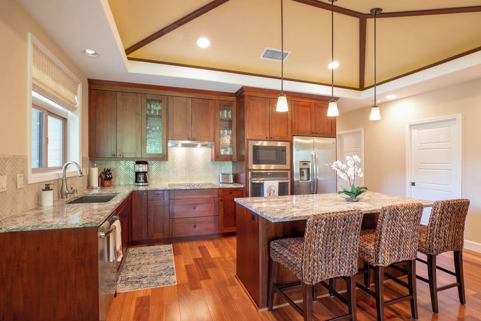 A chef’s dream kitchen awaits, equipped with granite counters, wine fridge, and top-tier appliances.