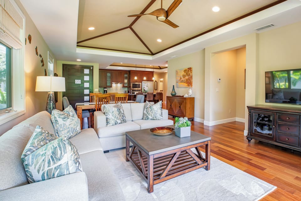 Gather in the open-concept living room, where vaulted ceilings and stylish island décor create an inviting retreat.