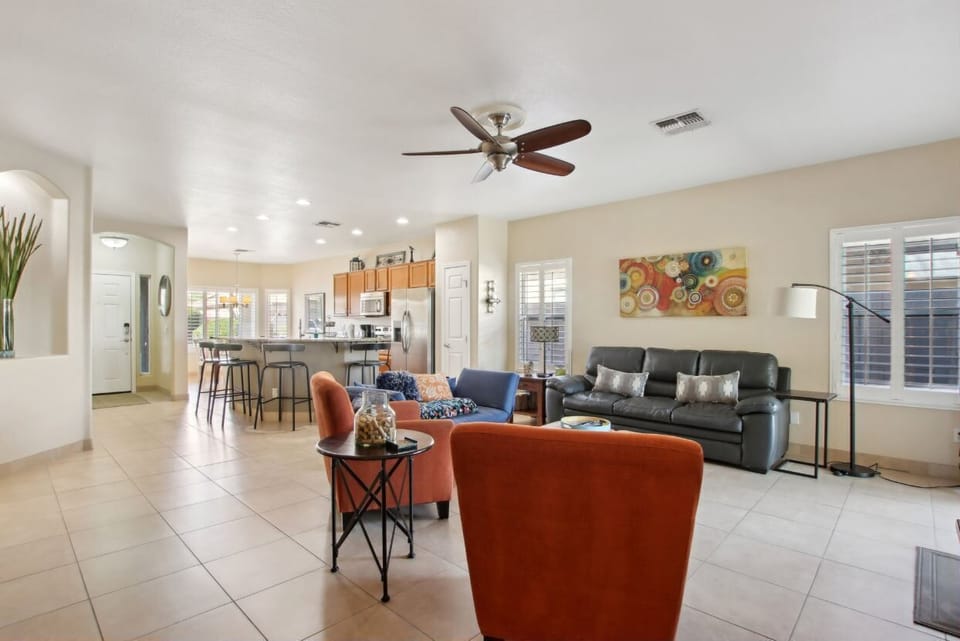 Living room that leads to covered patio and pool with kitchen in the background