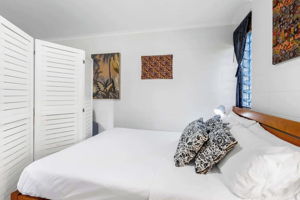 The louvred privacy screen creates a subtle separation between the bedroom and living area, offering added privacy while preserving the bright, open feel of the studio.