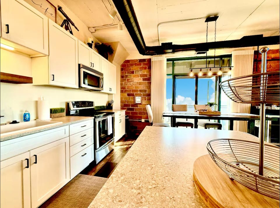 Chef’s Eye View
From the prep island to the brick-accented walls and wide-open patio door, every inch is designed for ease and inspired by the water beyond.