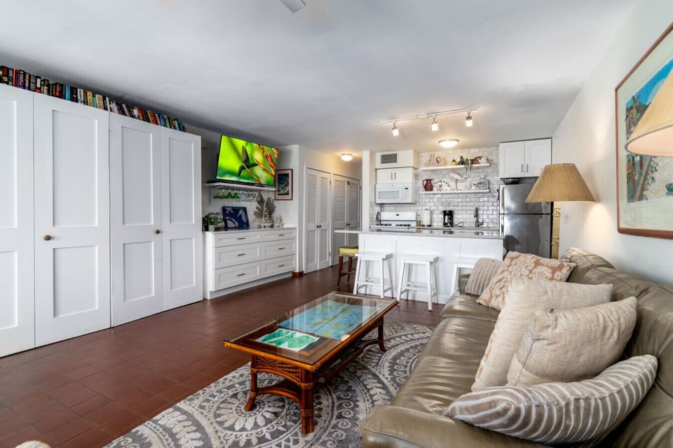 The spacious, comfy living room with the kitchen in the background.