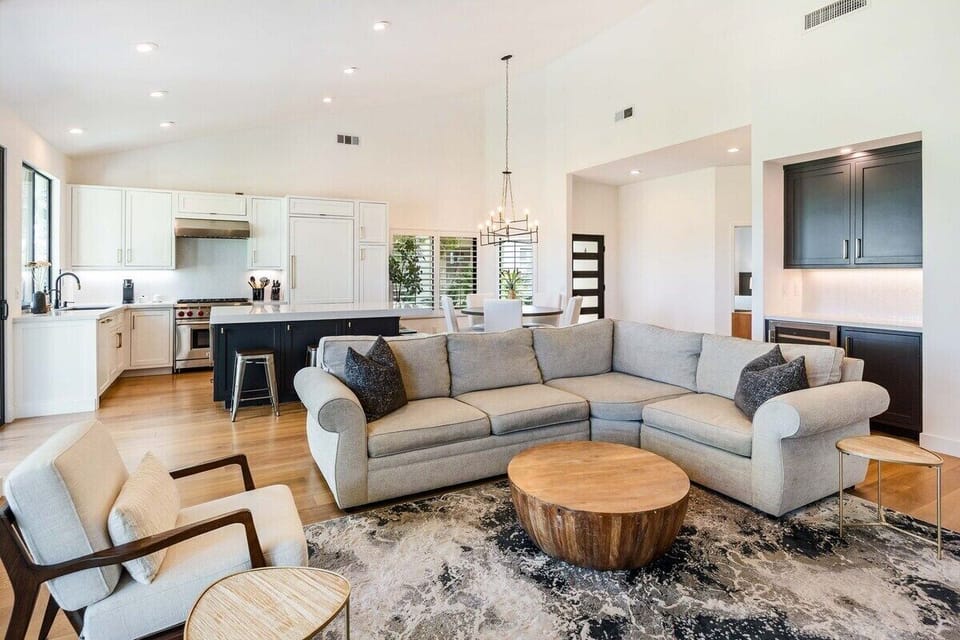 Open concept with sectional seating—bright space flows from living to kitchen.