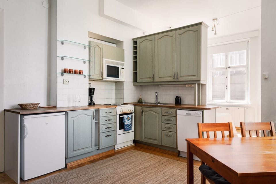 The kitchen features sleek cabinetry, quality cookware, and all the essential appliances—including a stove, oven, fridge, microwave, and kettle.