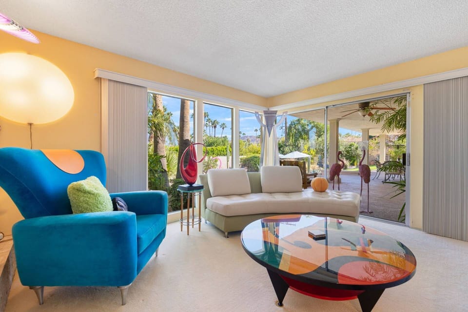 Contemporary living room filled with natural light, artistic touches, and relaxing garden views.