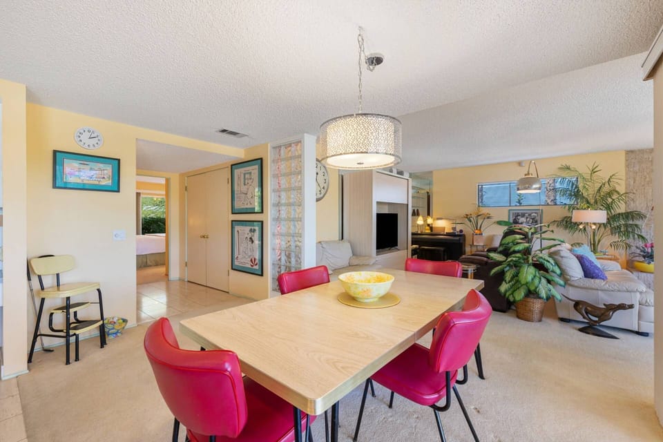 Bright and colorful dining area with retro-inspired décor and vibrant red chairs, perfect for cheerful gatherings.
