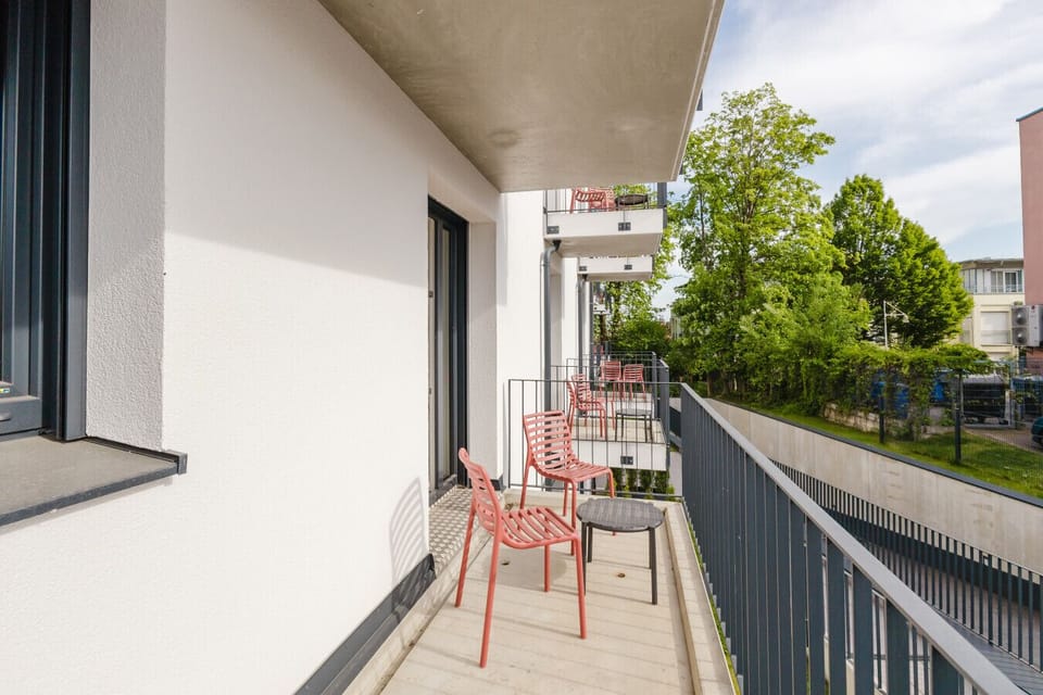 Großer Balkon mit moderner Möblierung und ruhiger Aussicht ins Grüne.