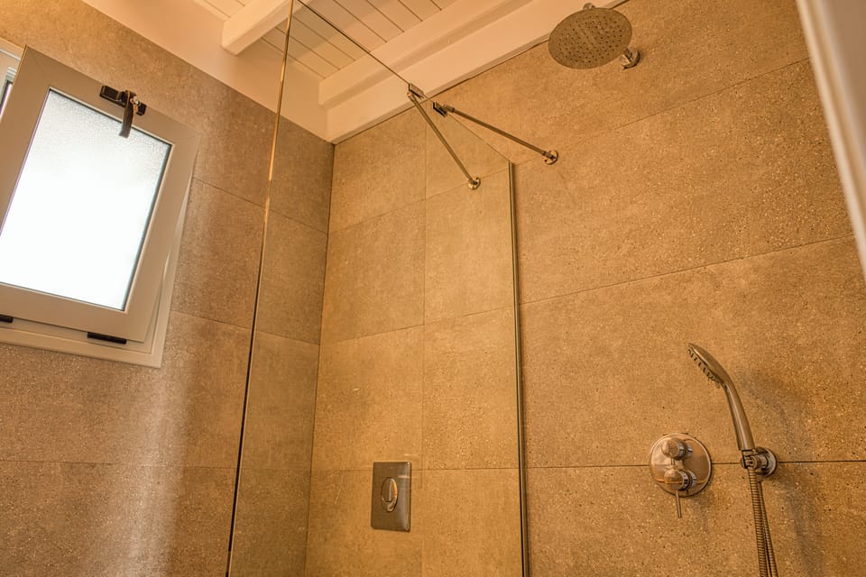 Deluxe Quadruple Room, Garden View | Bathroom | Shower, hair dryer, slippers, towels