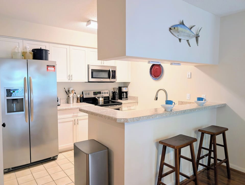 Modernized Gourmet Kitchen - Every inch of this kitchen is optimized for efficiency, boasting plenty of cabinet storage and a practical U-shaped layout. It’s a bright, functional workspace that makes beach-house meal prep a total pleasure.
