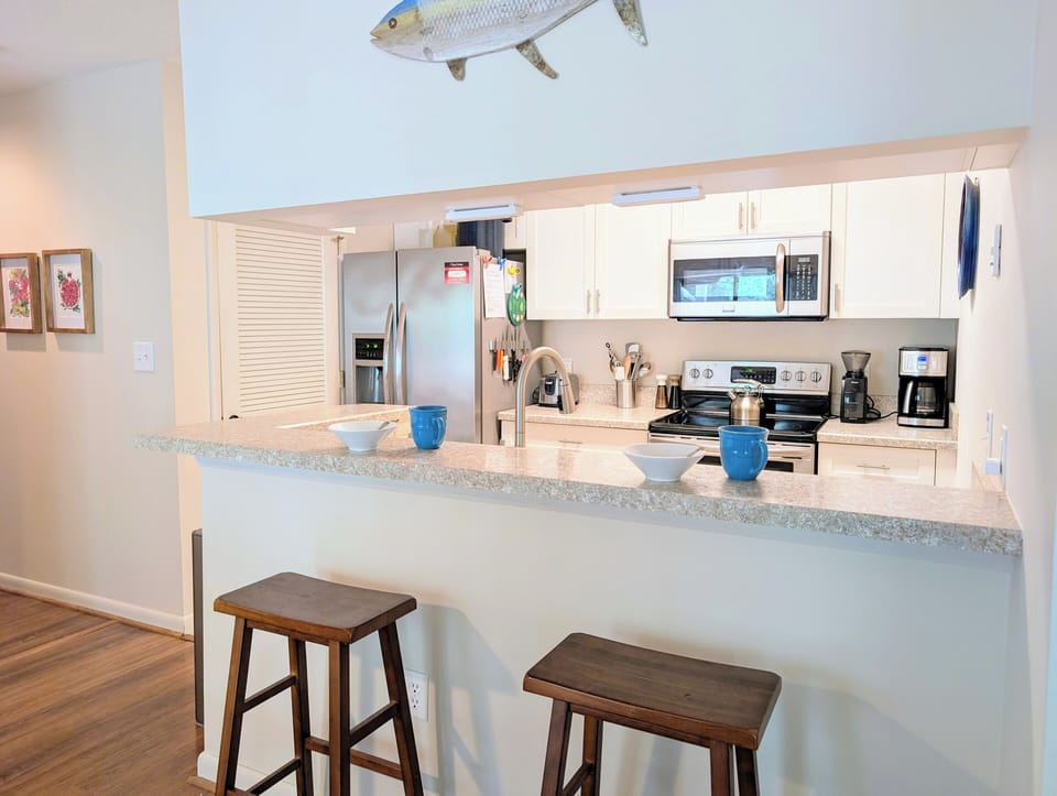 Social Kitchen Bar - The raised breakfast bar serves as a natural social hub, offering casual seating for quick meals or a place for guests to perch while the chef prepares dinner in the bright, updated kitchen.